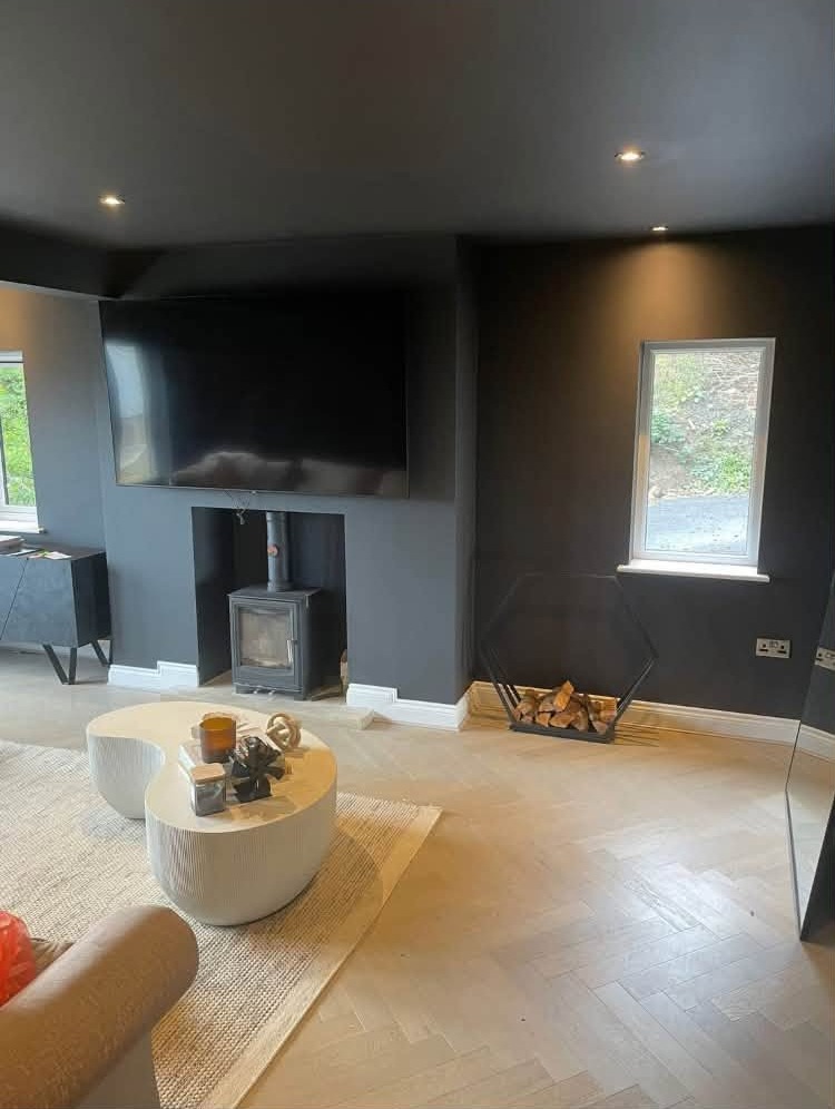 Charcoal lounge with a wood burner and white ceiling