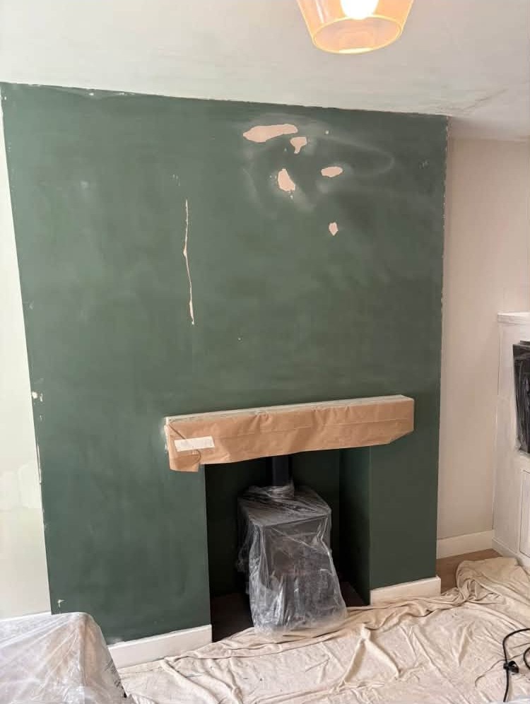 Green chimney breast patched with filler before painting