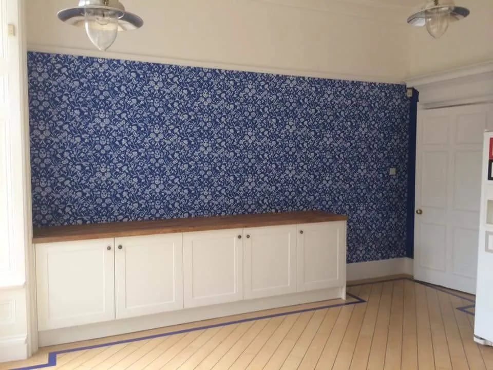 Blue patterned wall above white units